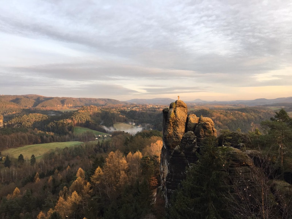 Die Brosinnadel, ein Sandsteinfelsen über der Sächsischen Schweiz, mit einem Bergsteiger auf der Spitze